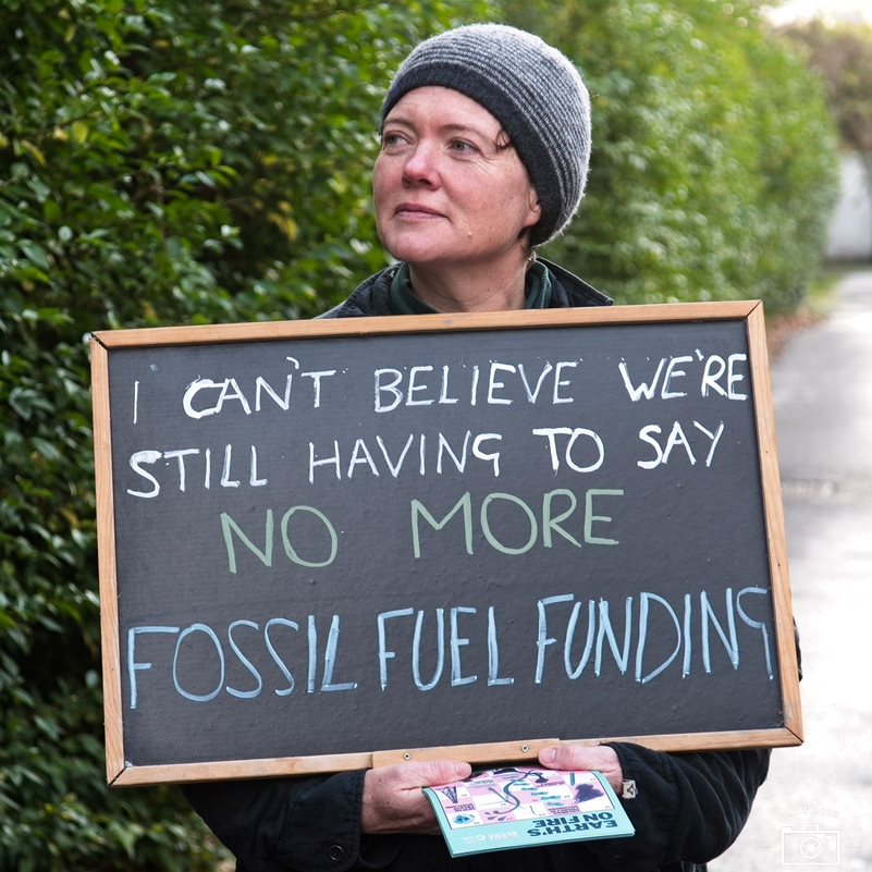 Stratford upon Avon Friends of the Earth member holding sign at fossil fuel day of action 2021