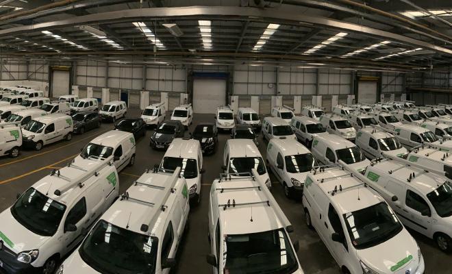 A warehouse full of white electric vans