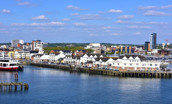 Houses and offices line the waterfront in full sun